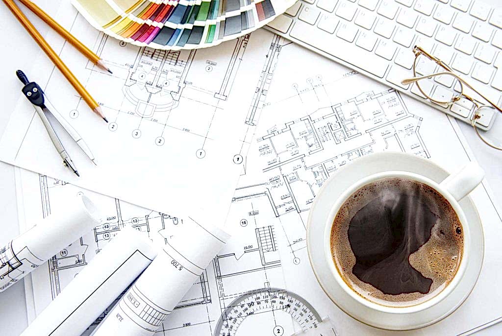 Architect workspace top view showing design plans, materials, sketches, and tools for interior planning